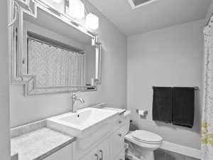 Bathroom with a shower with shower curtain, vanity, and dark tile patterned floors