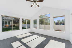 Unfurnished sunroom featuring carpet and lofted ceiling