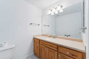 Half bath featuring vanity and light marble finish floors