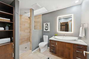 Full bathroom featuring vanity, a walk in shower, a spacious closet, and light tile patterned floors