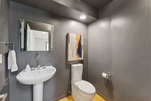 Half bath with wood finished floors and recessed lighting