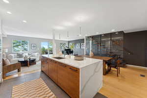 Kitchen featuring brown cabinets, modern cabinets, quartz counters, recessed lighting, and open floor plan. Custom Jarrah wood floating stairs.