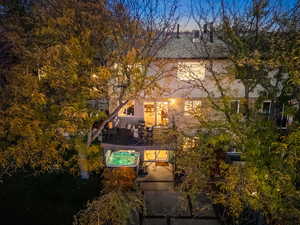 View of back of house with a patio and an outdoor hot tub