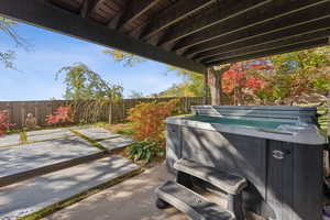 Fenced backyard featuring a hot tub and a patio area