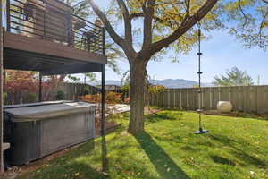 Fenced backyard featuring a mountain view and a hot tub