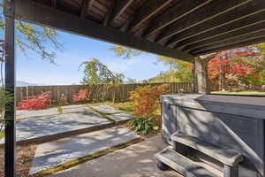 Fenced backyard with a hot tub and a patio area