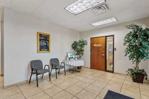 Foyer entrance with a paneled ceiling and light tile patterned flooring