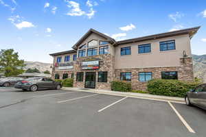 View of building exterior featuring a mountain view and uncovered parking