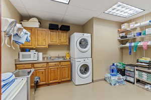 Washroom featuring a paneled ceiling and estacked washer and dryer