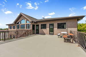 Back of house featuring stucco siding, a patio, and a shingled roof