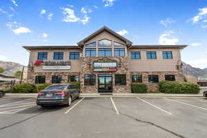 View of property with a mountain view and uncovered parking