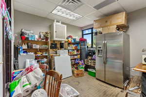 Kitchen featuring stainless steel fridge and a paneled ceiling