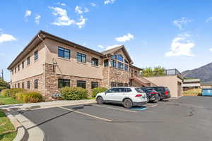 View of property featuring uncovered parking, stairs, and a mountain view