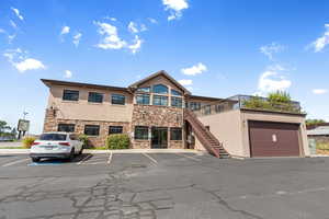 View of building exterior with stairway and uncovered parking