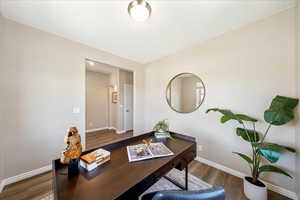Office area featuring baseboards and dark wood-style flooring
