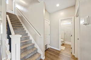 Stairs featuring wood finished floors and baseboards