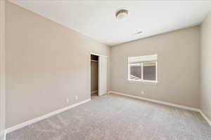 Unfurnished bedroom featuring carpet and a closet