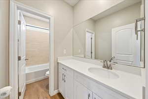 Bathroom with vanity, light wood finished floors, and shower / tub combination