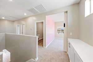 Hall featuring light colored carpet, recessed lighting, and an upstairs landing