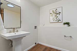 Bathroom with dark wood-style flooring and baseboards