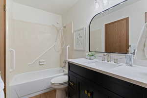 Bathroom with vanity, bathtub / shower combination, and light wood-style flooring
