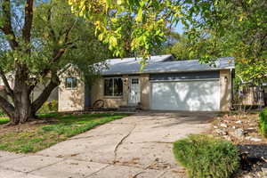 Single story home featuring driveway, brick siding, a garage, and a shingled roof