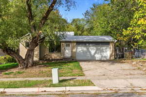 View of front of property featuring brick siding, driveway, and an attached garage