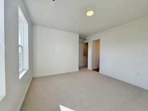 Carpeted spare room featuring baseboards