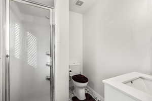 Bathroom with a shower stall, vanity, and tile patterned flooring