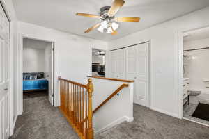 Hallway featuring carpet floors and an upstairs landing
