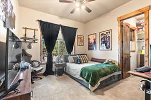 Bedroom with light colored carpet and a ceiling fan