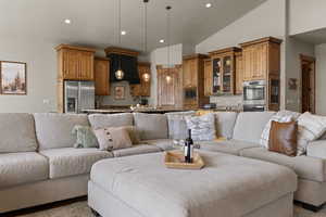 Living room featuring vaulted ceiling and recessed lighting