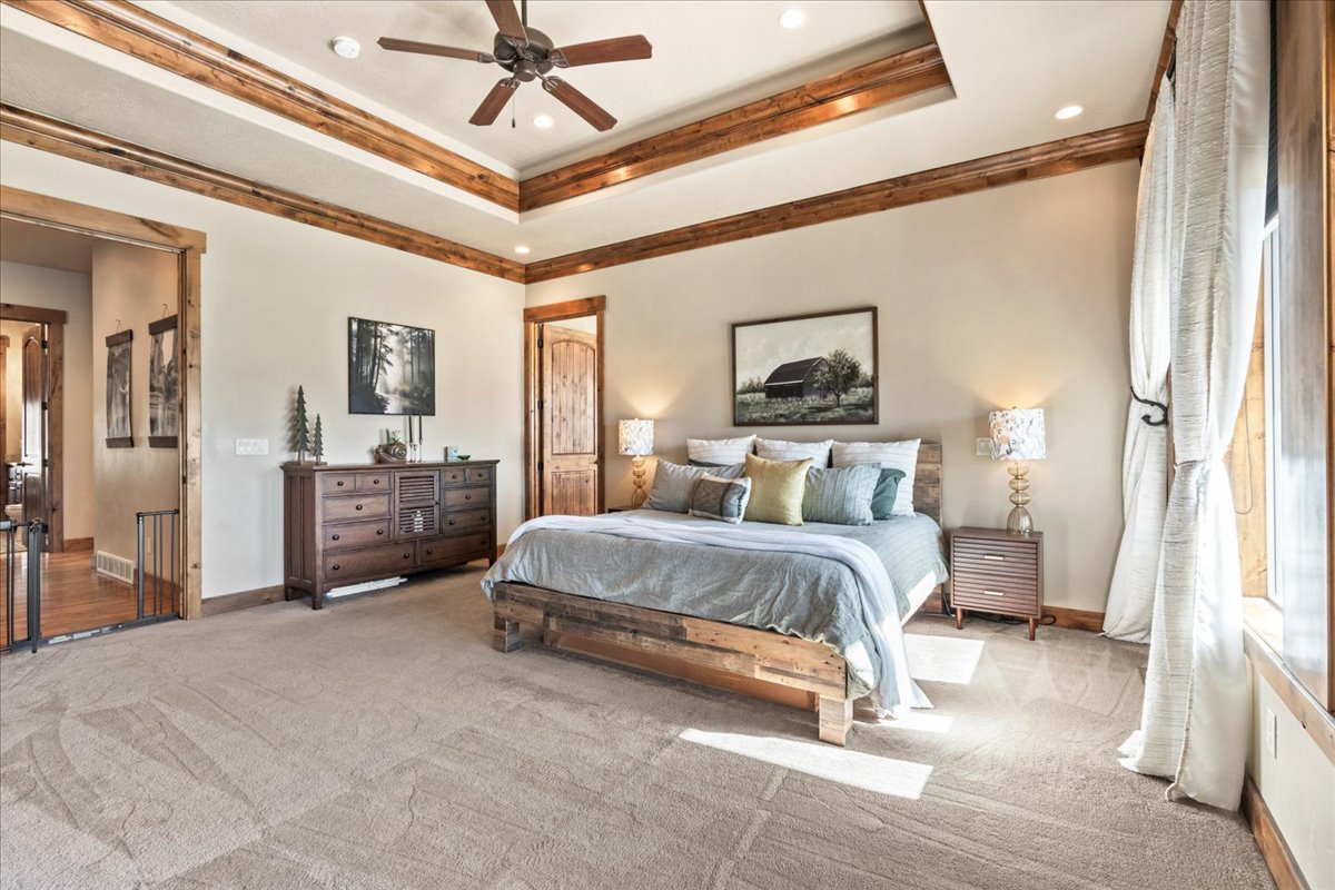Primary Bedroom with carpet flooring, a tray ceiling, ceiling fan, and recessed lighting