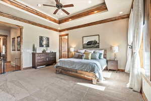 Bedroom with carpet flooring, a tray ceiling, ceiling fan, and recessed lighting