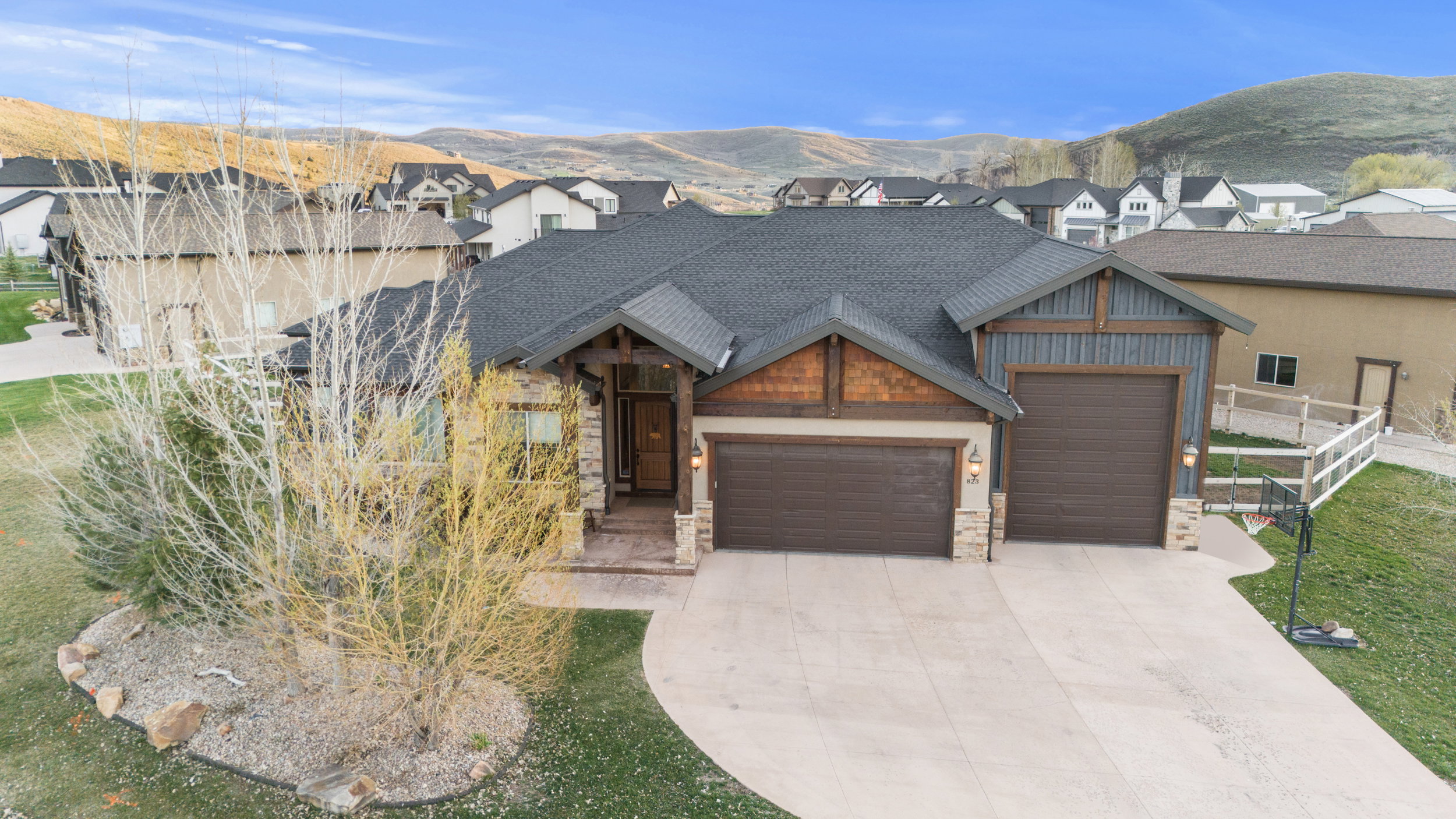 View of front of home with an attached garage, a mountain view, stone siding, and concrete driveway