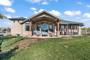 Rear view of property featuring stucco siding, a patio area, outdoor lounge area, and stone siding