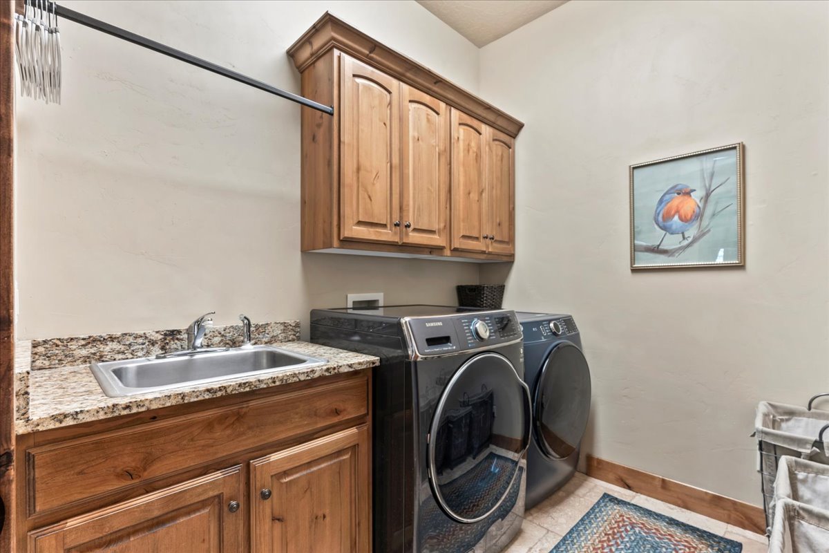 Laundry room with independent washer and dryer, cabinet space, and light tile patterned floors