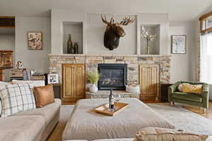 Living room with a glass covered fireplace and wood finished floors