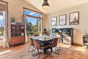 Dining area featuring light wood-style floors and lofted ceiling