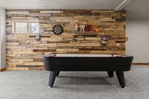 Air Hockey Game Table Recreation room with light carpet and wood walls