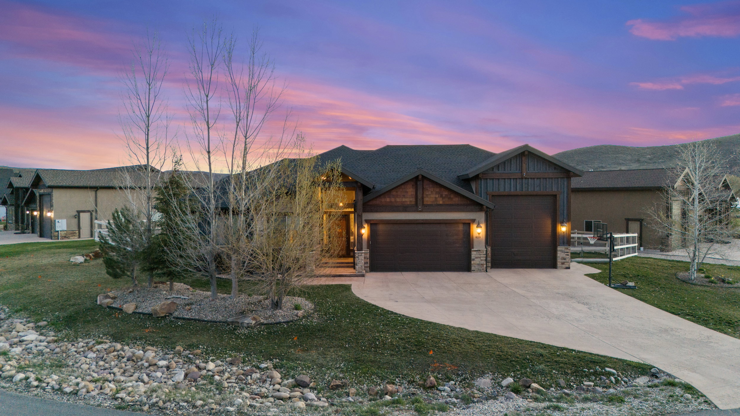 Craftsman inspired home with stone siding, an attached garage, a lawn, and concrete driveway