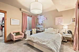 Carpeted bedroom featuring a walk in closet and baseboards