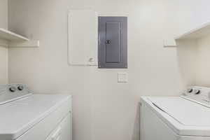 Laundry room featuring electric panel and washer and dryer