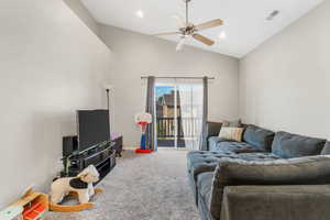 Carpeted living room featuring high vaulted ceiling, recessed lighting, and ceiling fan