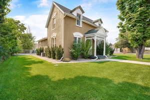 View of front of house with stucco siding and a shingled roof