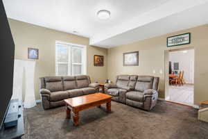 Living room with dark carpet and baseboards