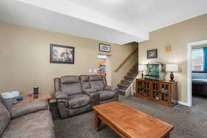 Living room with stairway and carpet floors