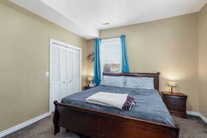 Bedroom with dark carpet and a closet