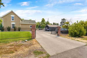 View of front of home featuring stucco siding, a gate, a fenced front yard, and concrete driveway