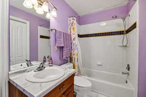 Full bathroom featuring vanity, shower / bathtub combination with curtain, and tile patterned floors